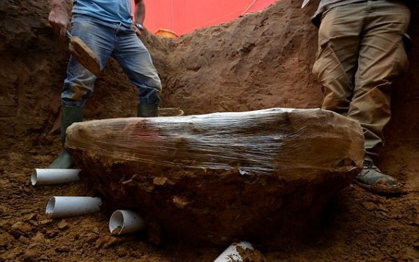 El equipo se prepara para sacar el bloque de monedas. Una vista lateral muestra el tamaño del bloque